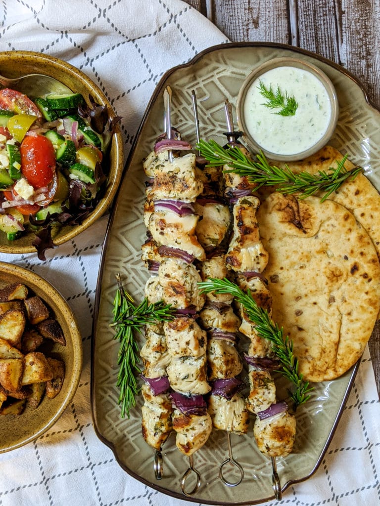 Grilled Chicken Kabobs on a platter with tzatziki sauce