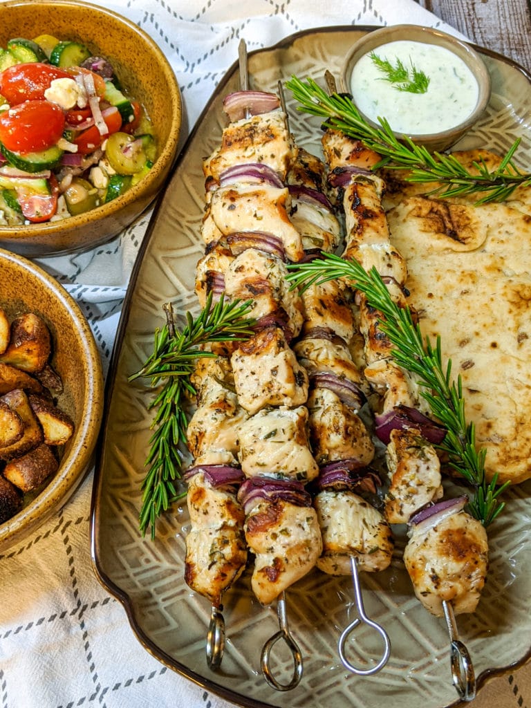 Grilled chicken souvlaki with tzatziki sauce and side dish