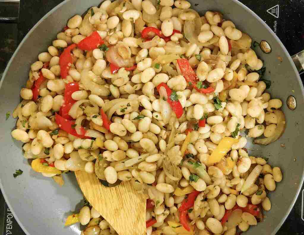 White bean salad cooking in a pan