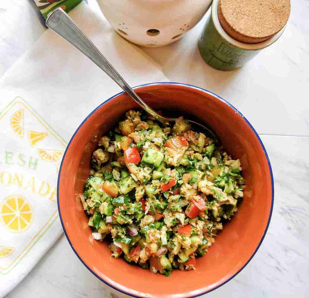 Cauliflower tabouleh in an orange bowl