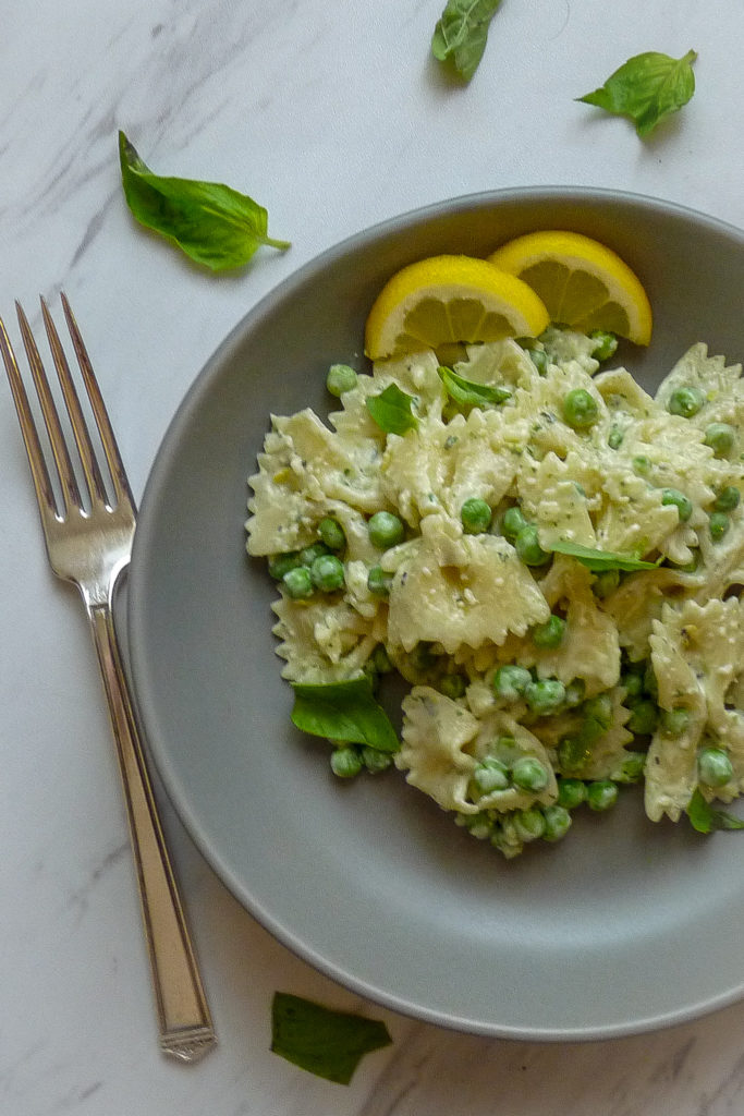 Lemon pasta salad in a grey bowl with lemon garnish