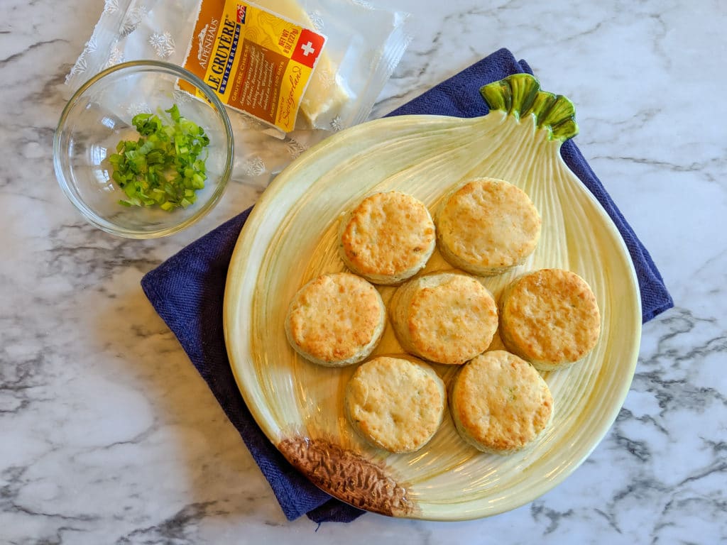 little gruyere biscuits on a plate with cheese and scallions