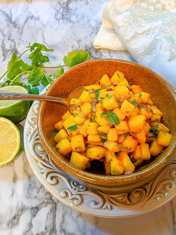 A bowl of mango salsa on a plate