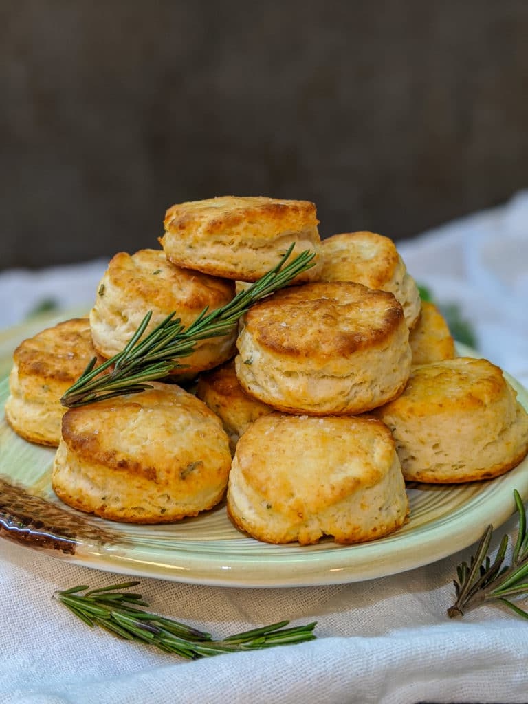 Rosemary Asiago Two Bite Biscuits on a plate garnished with fresh rosemary