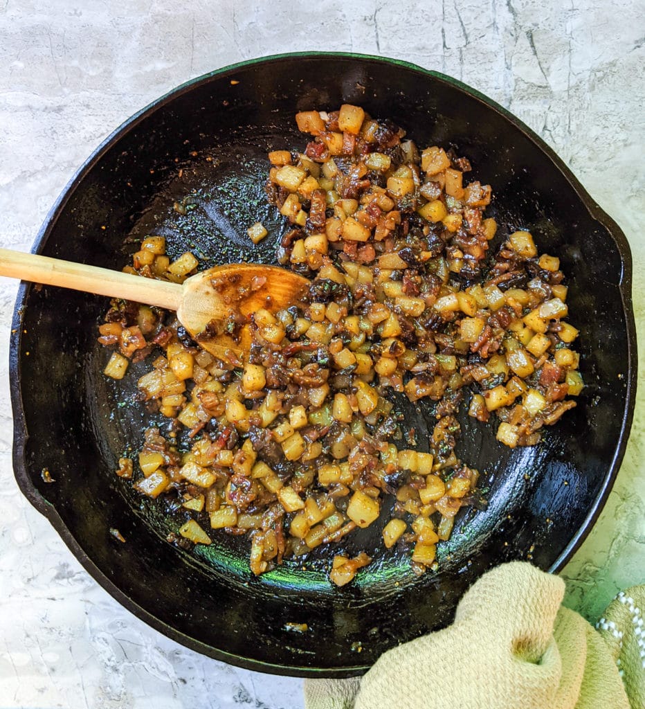 Pear, fig and bacon chutney cooking in a cast iron skillet