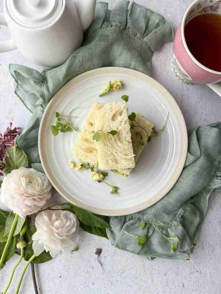 coronation chicken on a white plate with cup of tea