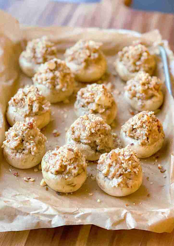 Sausage stuffed mushrooms on a sheet tray ready for the oven