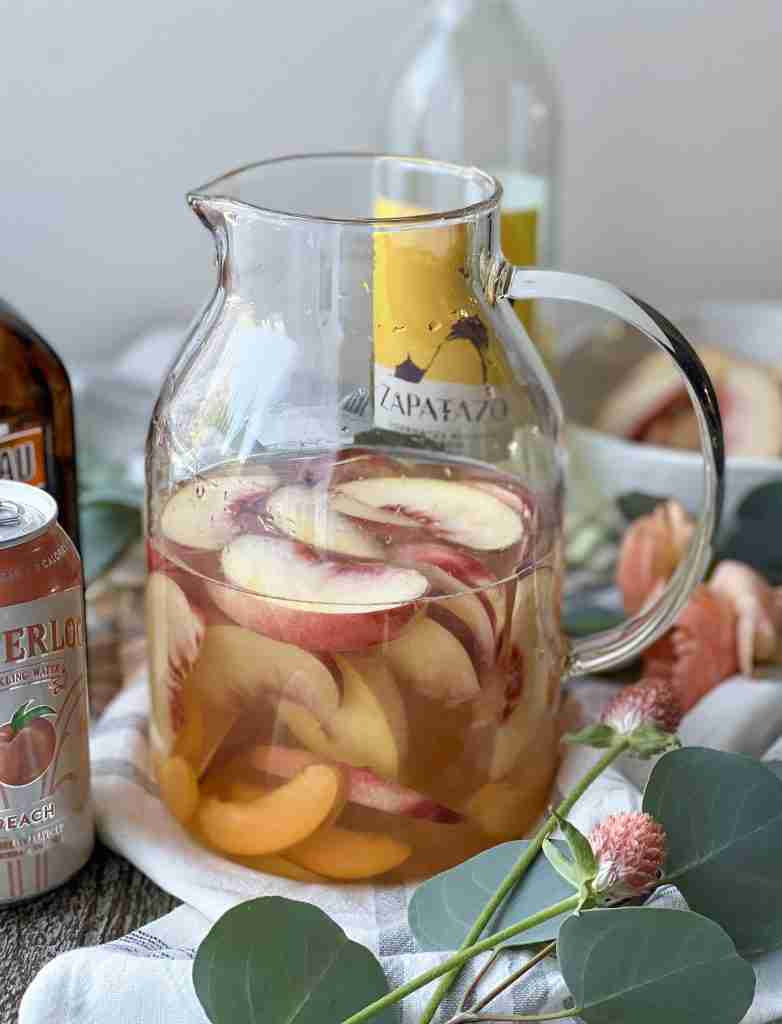 Wine and fruit in a pitcher sitting on a table